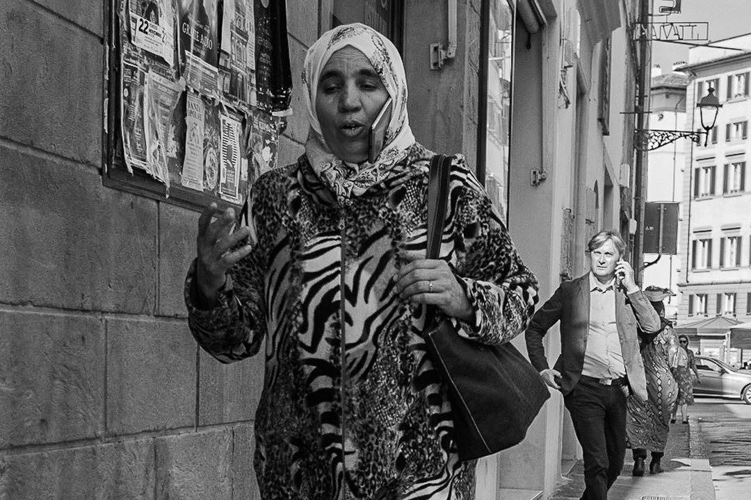 La fotografia, con un taglio abbastanza compresso, concentrato su un marciapiede cittadino, mostra un avvicendarsi di figure umane indaffarate nellanonima ordinaria frenesia della vita urbana. Pur migliorabile sotto il profilo della qualit tecnica, la f