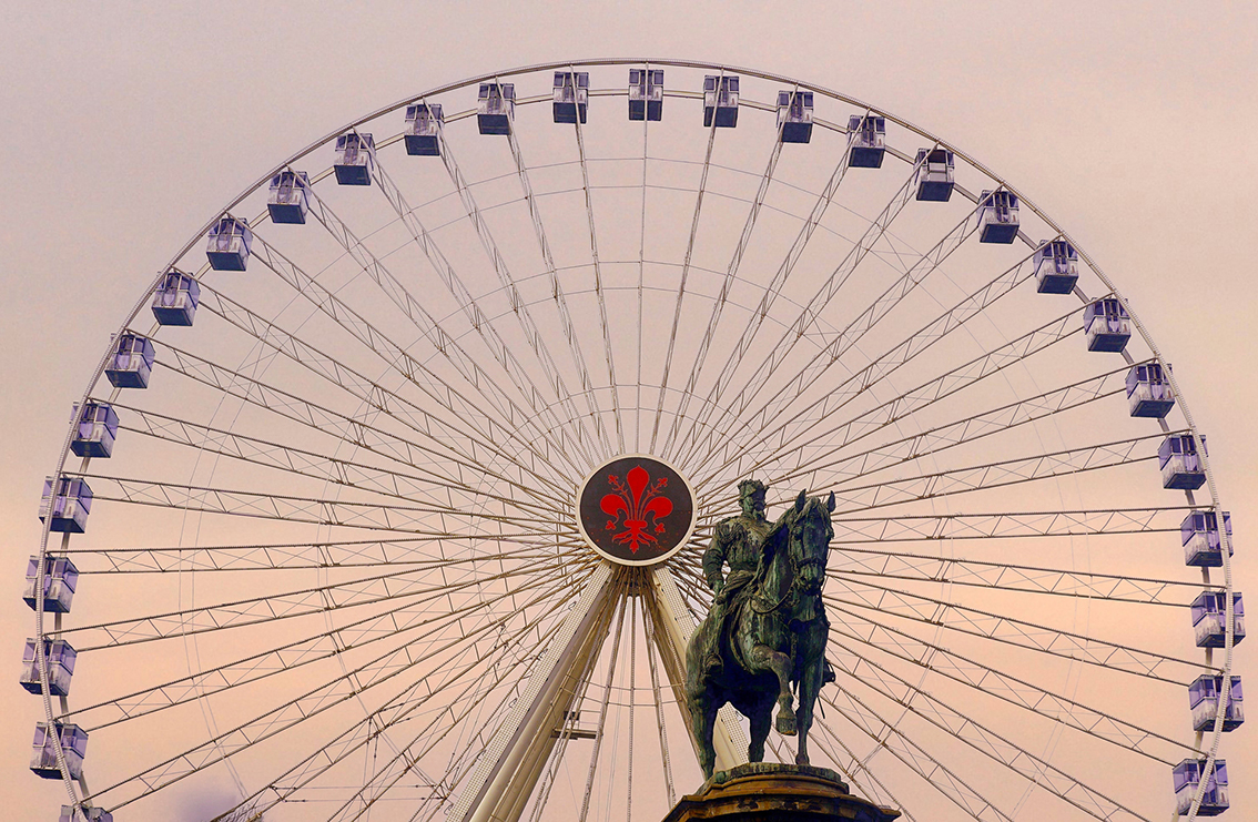 32 Il Re e la ruota  SESTA CLASS
IL PRISMA	VALERIO MECONCELLI
Limmagine propone unaffascinante sovrapposizione tra storia e modernit: la statua equestre, simbolo di autorit e tradizione, si staglia contro la ruota panoramica, espressione di svago e co